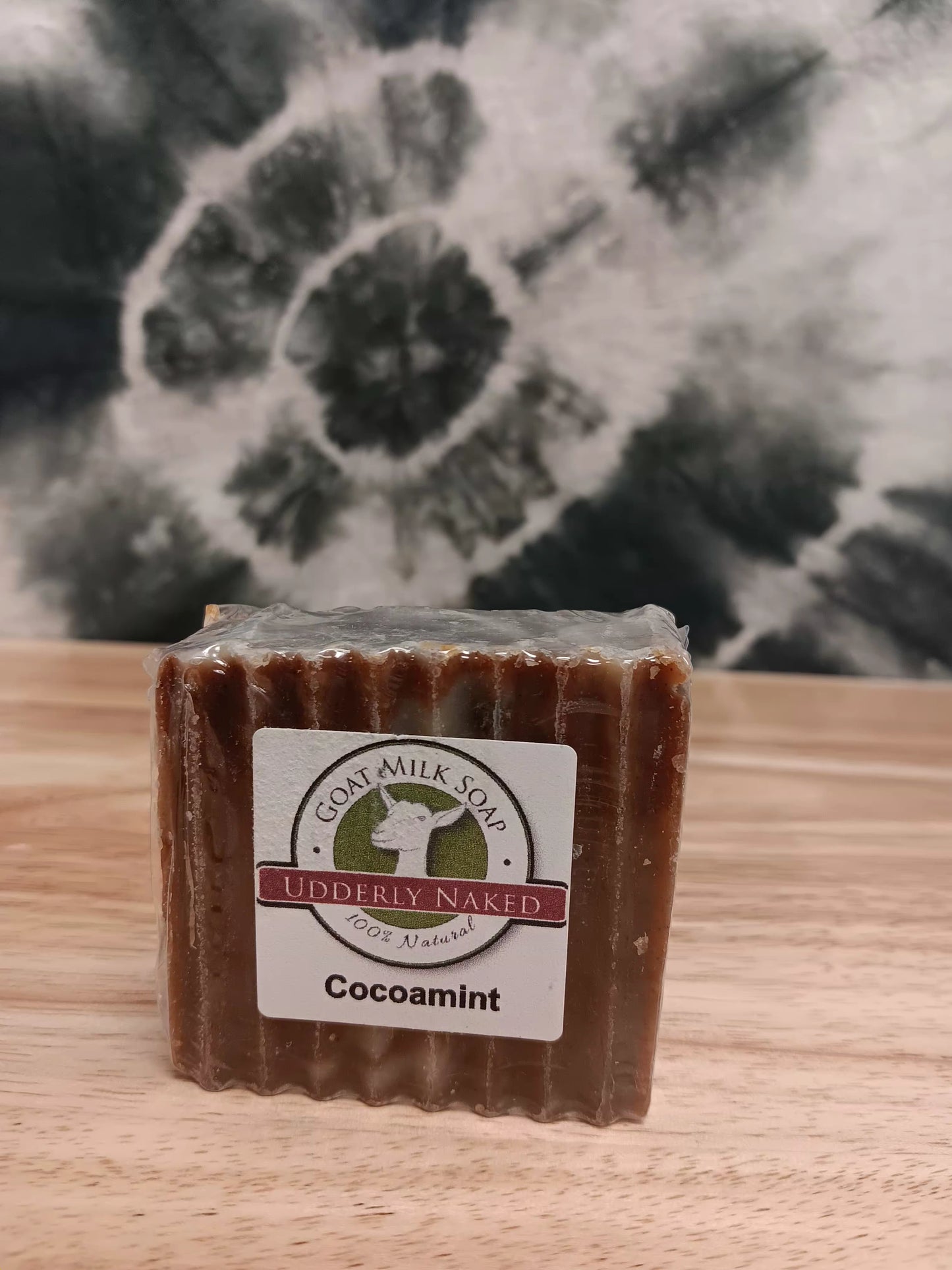 Bar of soap with a label on a wooden surface and floral background