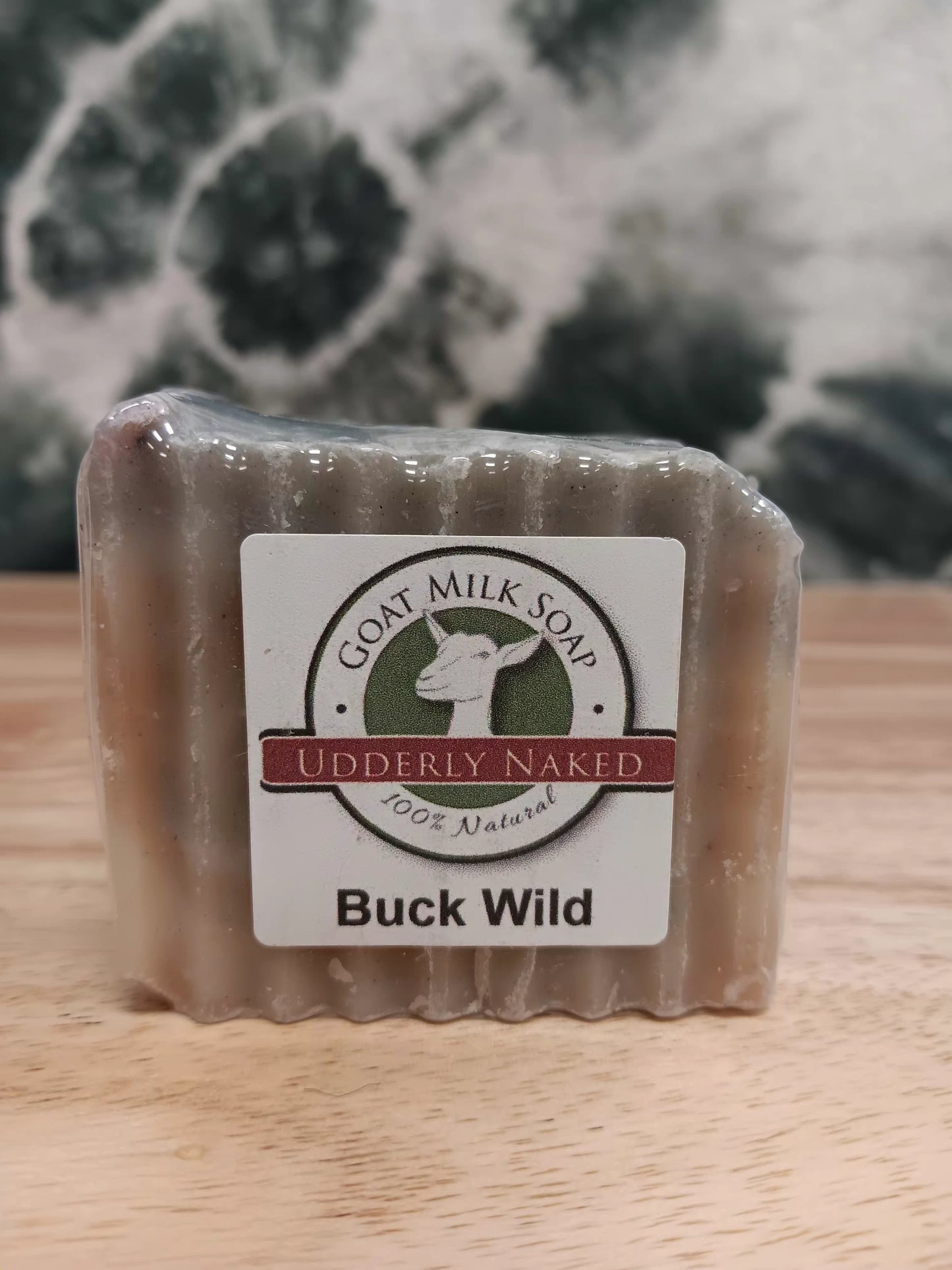 Bar of goat milk soap with a label on a wooden surface