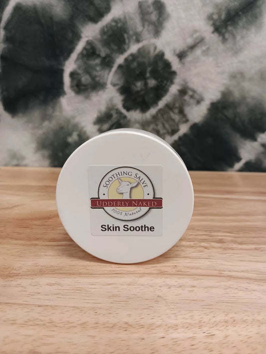 Container of 'Skin Soothe' salve with a label on a wooden surface